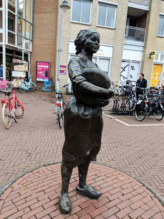Statue of a farm girl with a round of Gouda